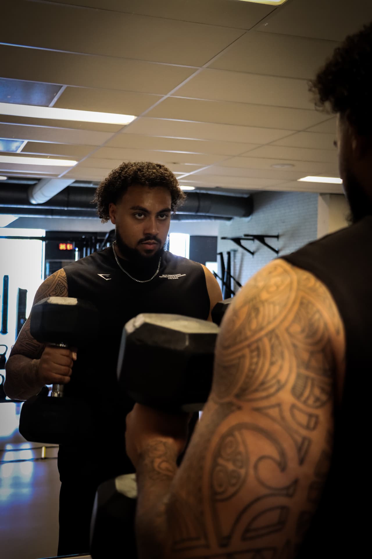 Bradley traint met dumbbells voor de spiegel